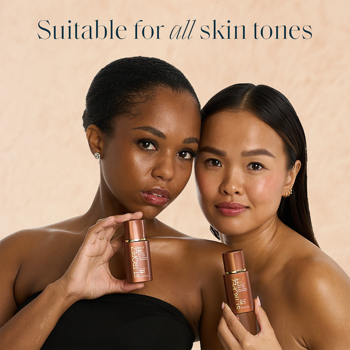 Two women with different skin tones holding St Tropez bronzing tint bottles suitable for all skin tones