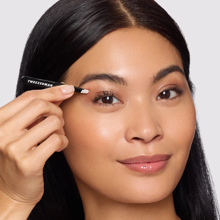 Tweezerman tweezer held by a woman for precise eyebrow grooming and shaping