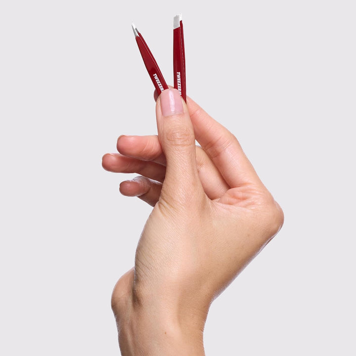 Tweezerman mini tweezer set in a hand, perfect for precision grooming and travel