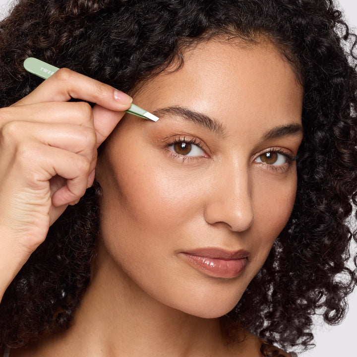 Tweezerman tweezers tweezer being used for precise hair removal on a woman's eyebrow