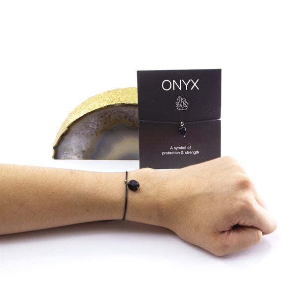 Wet Brush Mystical Crystal Detangler black onyx bracelet shown on wrist with protective strength symbol card