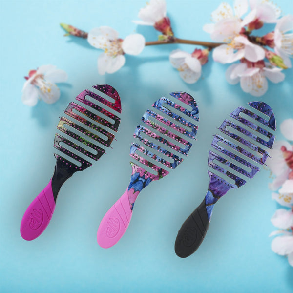 Wet Brush Pro Flex Dry hair brushes with colorful floral patterns and vented flexible heads on blue background