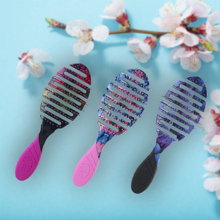 Wet Brush Pro Flex Dry hair brushes with colorful floral patterns and vented flexible heads on blue background
