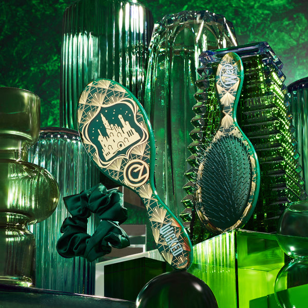 Wet Brush Wicked detangling brush with decorative design surrounded by green glass vases and scrunchies