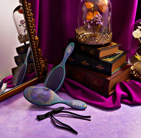 Wet Brush Wicked detangling brush with floral design placed near mirror and vintage books