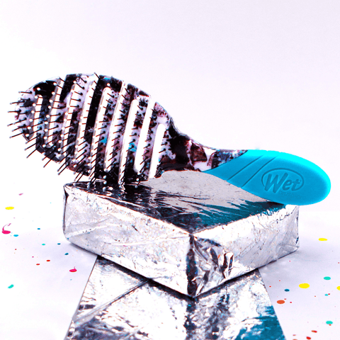 Wet Brush Street Art hairbrush with vented design and blue ergonomic handle on reflective silver surface