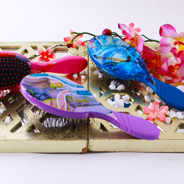 Colorful Wet Brush Zen Garden hair brush collection with floral background and decorative stones